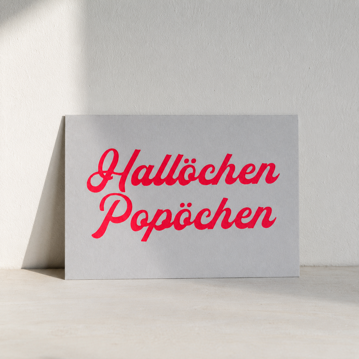 Postkarte „Hallöchen Popöchen" von DIE SIEBEREI, Siebdruck in Neonrot auf mattem Karton, Rückseite beschreibbar, DIN A6
